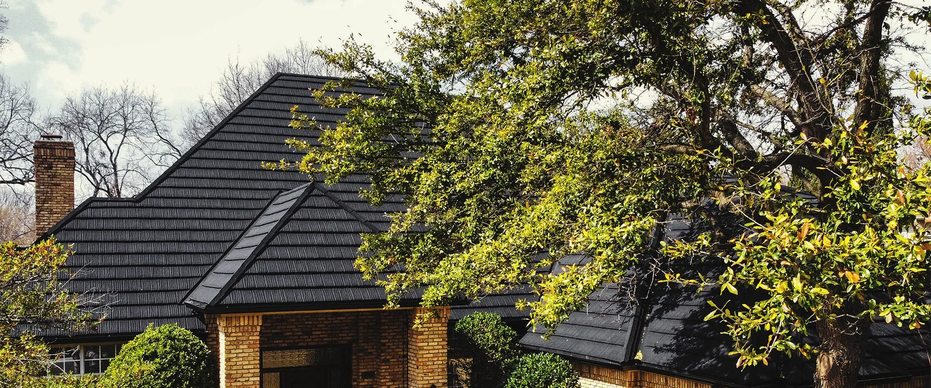 A beautiful two-story suburban home featuring a durable, dark charcoal stone-coated steel shingle roof by Tefute USA.