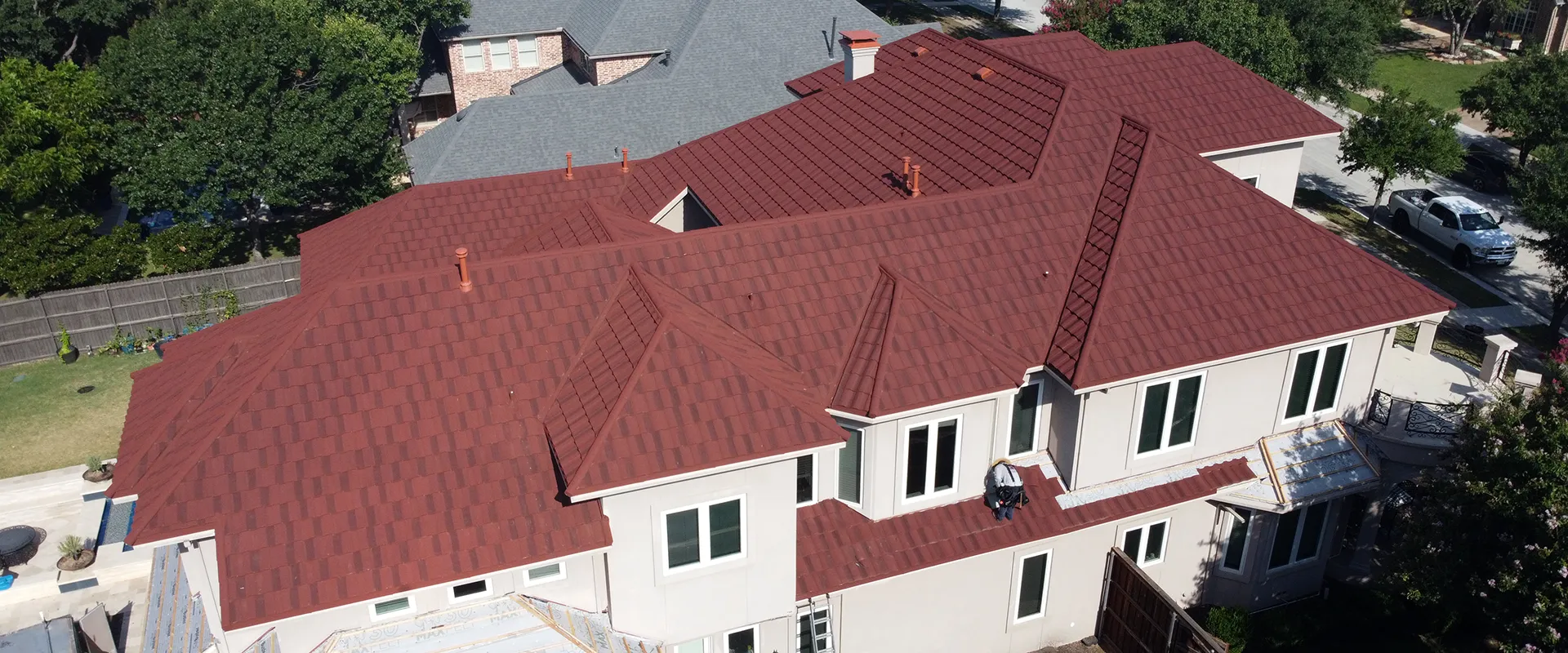 Close-up of Tefute USA's Roman style stone-coated steel roof tiles in a red and black color blend.